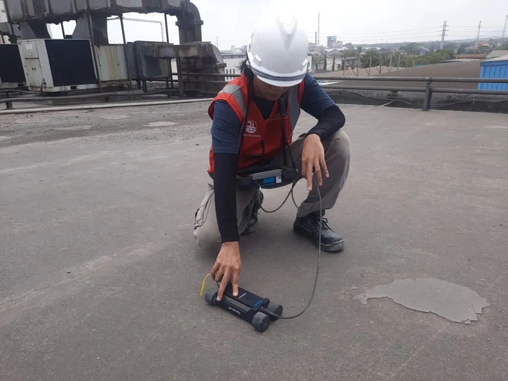 Teknisi HAZA memeriksa pelat beton menggunakan covermeter